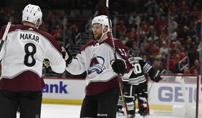 Colorado Avalanche&#x27;s Cale Makar (8) celebrates with teammate J.T. Compher (37) after scoring during the first period of an NHL hockey game against the Chicago Blackhawks Friday, Nov. 29, 2019, in Chicago. (AP Photo/Paul Beaty)