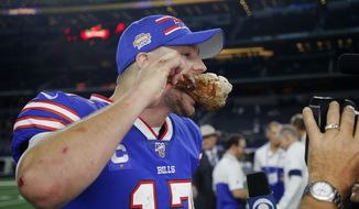 Buffalo Bills quarterback Josh Allen takes a bite out of a turkey leg as he participates in a broadcast interview after an NFL football game against the Dallas Cowboys in Arlington, Texas, Thursday, Nov. 28, 2019. (AP Photo/Michael Ainsworth)