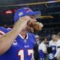 Buffalo Bills quarterback Josh Allen takes a bite out of a turkey leg as he participates in a broadcast interview after an NFL football game against the Dallas Cowboys in Arlington, Texas, Thursday, Nov. 28, 2019. (AP Photo/Michael Ainsworth)