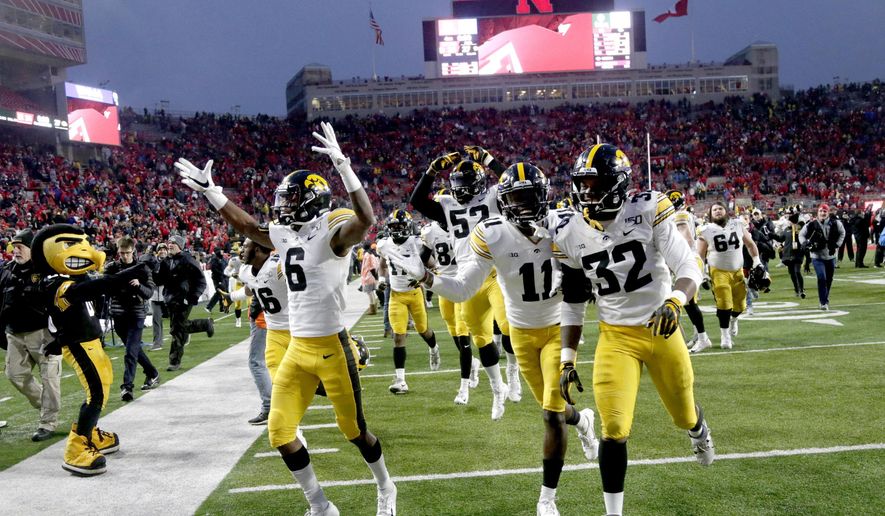 Iowa players including wide receiver Ihmir Smith-Marsette (6) and defensive back Michael Ojemudia (11) celebrate following an NCAA college football game against Nebraska in Lincoln, Neb., Friday, Nov. 29, 2019. Iowa won 27-24. (AP Photo/Nati Harnik)