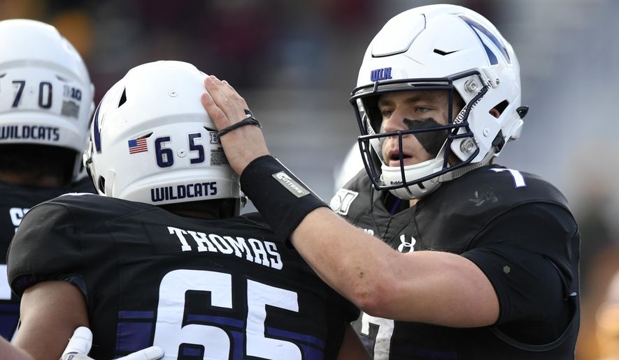 Northwestern quarterback Andrew Marty (7) celebrates with teammate Jared Thomas (65) after rushing for a touchdown during the second half of an NCAA football game against Minnesota Saturday, Nov. 23, 2019, in Evanston, Ill. Minnesota won 38-22. (AP Photo/Paul Beaty)