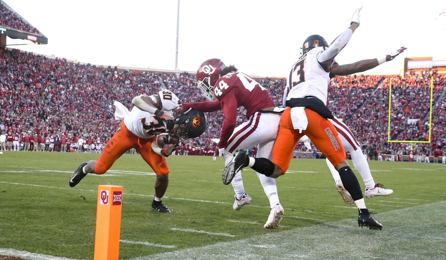 FILE - In this Nov. 10, 2018, file photo, Oklahoma defensive back Brendan Radley-Hiles (44) tackles Oklahoma State running back Chuba Hubbard (30) during an NCAA college football game in Norman, Okla. For the four-time defending Big 12 champion Sooners, still trying to get back to the College Football Playoff for the fourth time in five seasons, Bedlam is another long standing rivalry against a Big 12 foe. (Ian Maule/Tulsa World via AP, File)