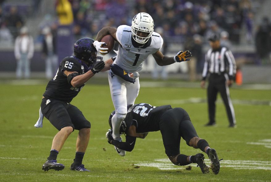 TCU defensive end Wyatt Harris (25) and safety Ar'Darius Washington (27) try to stop the run by West Virginia wide receiver T.J. Simmons (1) in the first half of an NCAA college football game Friday, Nov. 29, 2019, in Fort Worth, Texas. (AP Photo/Richard W. Rodriguez)