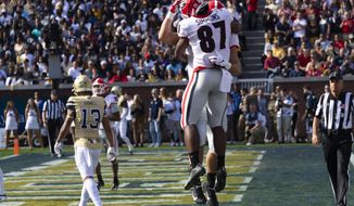 Georgia wide receiver Tyler Simmons (87) celebrates a touchdown with tight end Charlie Woerner during the first half of an NCAA college football game against Georgia Tech, Saturday, Nov. 30, 2019 in Atlanta. Woerner scored on the play. (AP Photo/John Amis)