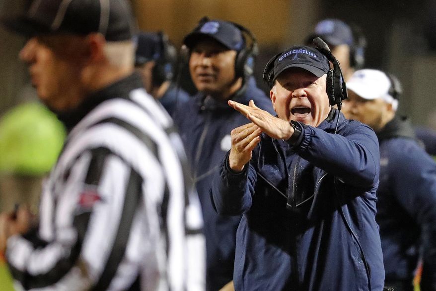 North Carolina head coach Mack Brown runs to take a timeout during the first half of an NCAA college football game against North Carolina State in Raleigh, N.C., Saturday, Nov. 30, 2019. (AP Photo/Karl B DeBlaker)