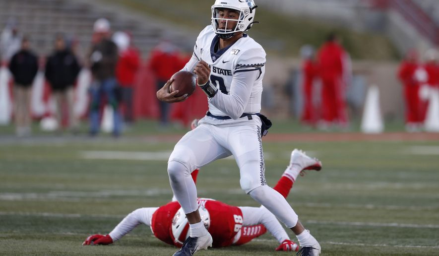Utah State quarterback Jordan Love (10) runs for yardage after avoiding the tackle by New Mexico defensive lineman Joey Noble (98) during the second half of an NCAA college football game on Saturday, Nov. 30, 2019 in Albuquerque, N.M. (AP Photo/Andres Leighton)