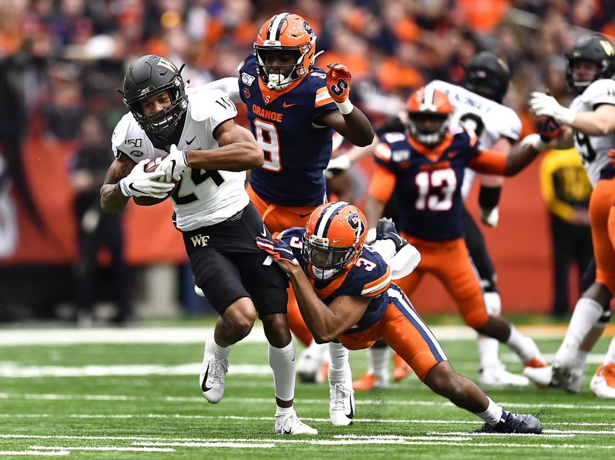 Wake Forest wide receiver Donavon Greene, left, is tackled by Syracuse defensive back Christopher Fredrick after a reception during the first half of an NCAA college football game in Syracuse, N.Y., Saturday, Nov. 30, 2019. (AP Photo/Adrian Kraus)
