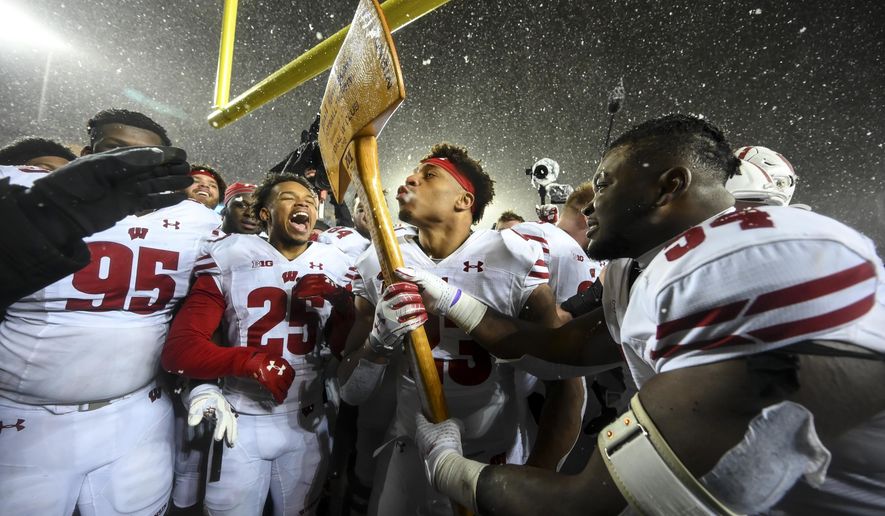 Wisconsin running back Jonathan Taylor (23) kisses Paul Bunyan's Axe after the team's victory over Minnesota during an NCAA college football game Saturday, Nov. 30, 2019, in Minneapolis. (Aaron Lavinsky/Star Tribune via AP)