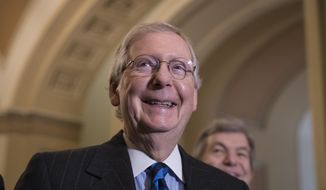 Senate Majority Leader Mitch McConnell, R-Ky., smiles as he meets with reporters as work continues on a plan to keep the government as a funding deadline approaches, at the Capitol in Washington, Tuesday, Feb. 6, 2018. (AP Photo/J. Scott Applewhite)