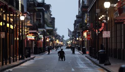 A man in a wheelchair makes his way down Bourbon Street in the French Quarter Saturday, July 13, 2019, in New Orleans, as Tropical Storm Barry nears landfall. (AP Photo/David J. Phillip)