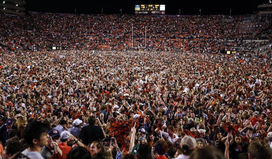 Auburn fans storm the field after they defeated Alabama 48-45 in an NCAA college football game Saturday, Nov. 30, 2019, in Auburn, Ala. (AP Photo/Butch Dill)