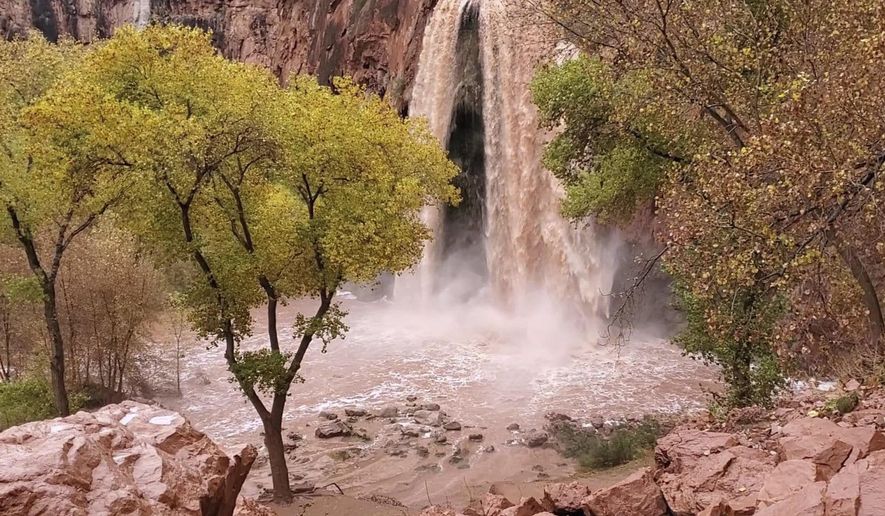 This Nov. 29, 2019, photo, shows a normally blue-green waterfall in Supai, Arizona, that turned chocolate brown after flooding. A popular tourist spot deep in a gorge off the Grand Canyon was flooded over the holiday, sending tourists scrambling to higher ground. The flood happened just days before the Havasupai Tribe shuts down its reservation to tourists for the season. No one was injured but some tourists woke up drenched and some lost camping gear. (Mandy Augustin via AP)