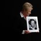 In this Nov. 20, 2019, photo, Nancy Holling-Lonnecker, 71, poses with a picture taken of her as a young girl, at her home in San Diego. Holling-Lonnecker plans to take advantage of an upcoming three-year window in California that allows people to make claims of sexual abuse no matter how old. Her claim dates back to the 1950s when she says a priest repeatedly raped her in a confession booth beginning when she was 7 years old. “The survivors coming forward now have been holding on to this horrific experience all of their lives,” she said. (AP Photo/Gregory Bull)