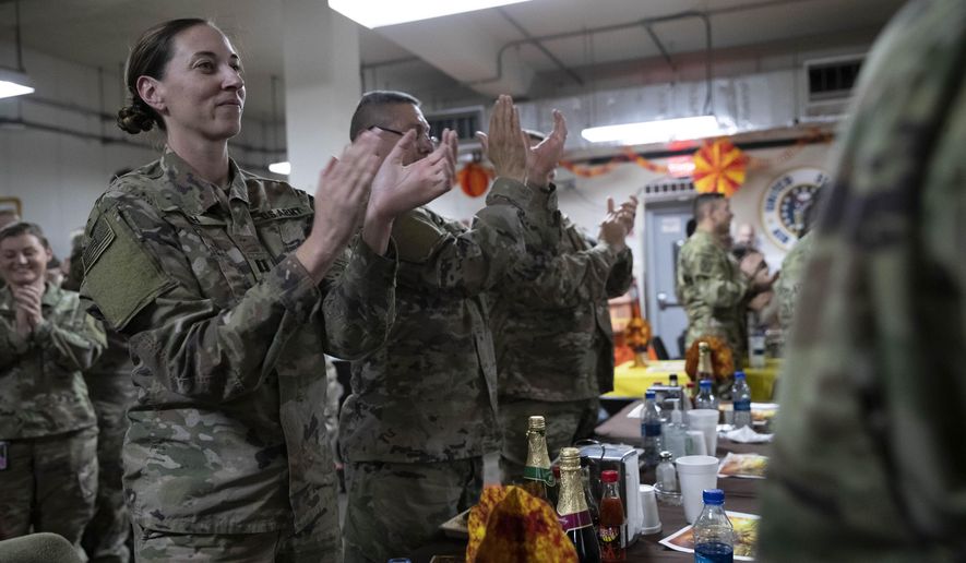 Members of the military applaud as President Donald Trump speaks at a dinning facility during a surprise Thanksgiving Day visit, Thursday, Nov. 28, 2019, at Bagram Air Field, Afghanistan. (AP Photo/Alex Brandon)