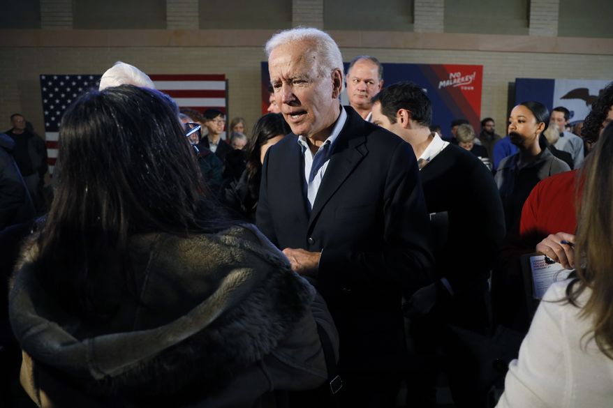 Democratic presidential candidate former Vice President Joe Biden greets audience members during a bus tour stop, Tuesday, Dec. 3, 2019, in Mason City, Iowa. (AP Photo/Charlie Neibergall)
