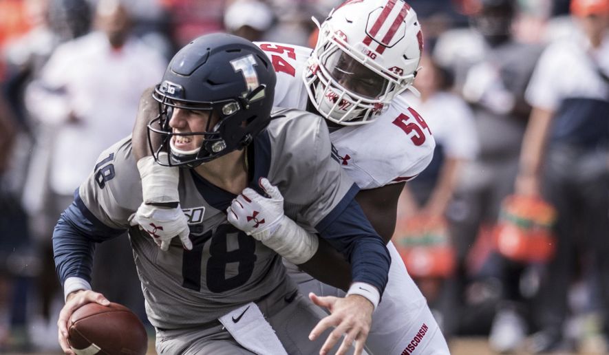 FILE - In this Oct. 19, 2019, file photo, Illinois quarterback Brandon Peters (18) is sacked by Wisconsin's Chris Orr (54) in the second half of an NCAA college football game, in Champaign, Ill. Championship weekend crowns the winner of 10 FBS conferences and matches up some big-time players. Wisconsin and Ohio State will meet for the Big Ten Championship. (AP Photo/Holly Hart, File)