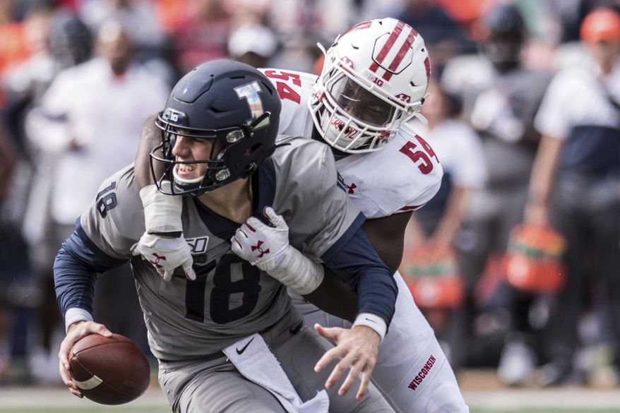 FILE - In this Oct. 19, 2019, file photo, Illinois quarterback Brandon Peters (18) is sacked by Wisconsin's Chris Orr (54) in the second half of an NCAA college football game, in Champaign, Ill. Championship weekend crowns the winner of 10 FBS conferences and matches up some big-time players. Wisconsin and Ohio State will meet for the Big Ten Championship. (AP Photo/Holly Hart, File)