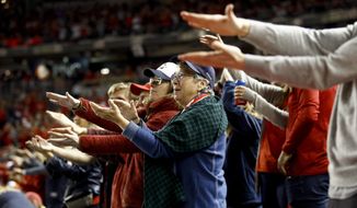 FILE - In this Oct. 25, 2019, file photo, fans gesture the baby shark as Washington Nationals&#39; Gerardo Parra bats during the sixth inning of Game 3 of the baseball World Series against the Houston Astros, in Washington. Creators of the viral video “Baby Shark,” whose “doo doo doo” song was played at the World Series in October, are developing a version in Navajo. (AP Photo/Patrick Semansky, File)