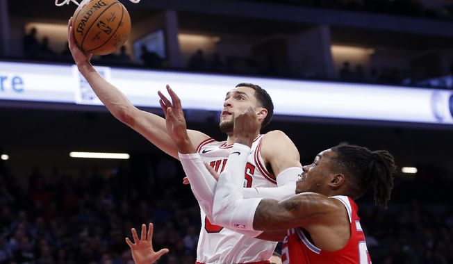 Chicago Bulls guard Zach LaVine, left, goes to the basket against Sacramento Kings forward Richaun Holmes, right, during the first quarter of an NBA basketball game Monday, Dec. 2, 2019, in Sacramento, Calif. (AP Photo/Rich Pedroncelli)