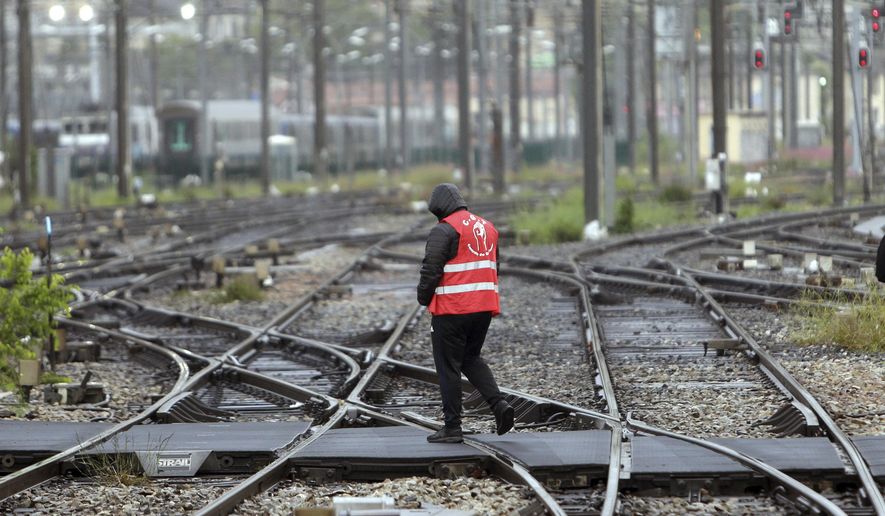 FILE - In this May 14, 2018 file photo, a striking rail worker walks on the tracks of the Saint-Charles train station, in Marseille, southern France. France's rail operator SNCF and the Paris Metro say nationwide strikes will wipe out most services Thursday, impacting millions. The SNCF expects that 9 out of 10 high-speed trains won't run and that half of the Eurostar services linking France and Britain will be canceled, too. (AP Photo/Claude Paris, File)