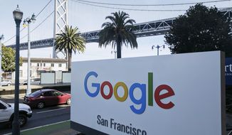 FILE - In this Oct. 31, 2018, file photo shows signage outside the offices of Google in San Francisco with the San Francisco-Oakland Bay Bridge in the background. Four workers fired from Google in November 2019 are planning to file charges against the company with a federal agency. They are claiming the company unfairly retaliated against them for organizing workers around social causes. (AP Photo/Michael Liedtke, File)