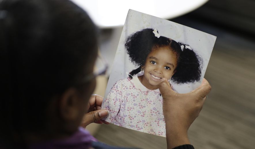 In this Oct. 29, 2019, photo, Donnesha Cooper touches a photo of her daughter, Alianna DeFreeze, in Cleveland. Her daughter’s murder and the murder of Reagan Tokes had a lot in common. Yet only one victim got a law with her name on it, Tokes, who was white. An Associated Press analysis found that more than 8 in 10 stand-alone laws named for victims of violent crime identified since 1990 honored white victims or groups of victims that included at least one white person. That has left black victims such as DeFreeze underrepresented by such laws. (AP Photo/Tony Dejak)