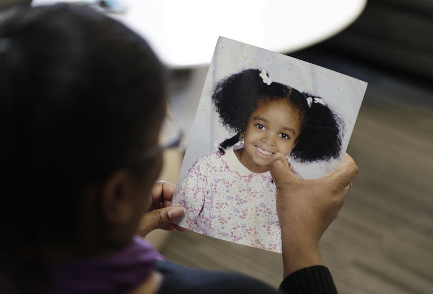 In this Oct. 29, 2019, photo, Donnesha Cooper touches a photo of her daughter, Alianna DeFreeze, in Cleveland. Her daughter’s murder and the murder of Reagan Tokes had a lot in common. Yet only one victim got a law with her name on it, Tokes, who was white. An Associated Press analysis found that more than 8 in 10 stand-alone laws named for victims of violent crime identified since 1990 honored white victims or groups of victims that included at least one white person. That has left black victims such as DeFreeze underrepresented by such laws. (AP Photo/Tony Dejak)