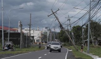 Vehicles pass by toppled electrical poles as Typhoon Kammuri slammed Legazpi city, Albay province, southeast of Manila, Philippines on Tuesday, Dec. 3, 2019. A powerful typhoon was blowing across the Philippines on Tuesday after slamming ashore overnight in an eastern province, damaging houses and an airport and knocking out power after tens of thousands of people fled to safer ground. (AP Photo)