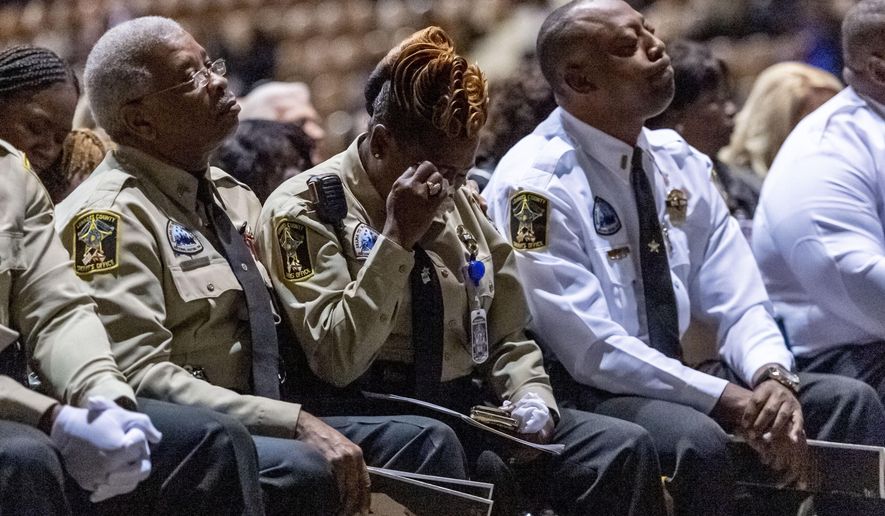 Members of the Lowndes County Sheriff's office are overcome with emotion as the 'end of watch' is dispatched over the air, ending the memorial service for slain Lowndes County Sheriff "Big John" Williams, Monday, Dec. 2, 2019, in Montgomery, Ala. (AP Photo/Vasha Hunt)
