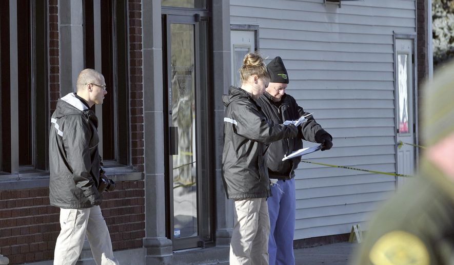 Investigators with Iowa Division of Criminal Investigation and Kossuth County Medical Examiner Mark Davis compare notes Wednesday afternoon, Dec. 4, 2019, at the scene of a robbery and homicide at the Security State Bank in Lu Verne, Iowa. (Hans Madsen/The Messenger via AP)