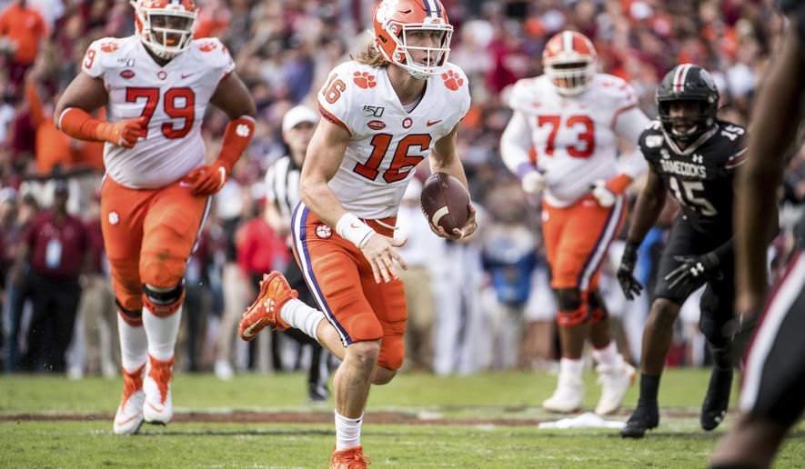 FILE - In this Nov. 30, 2019, file photo, Clemson quarterback Trevor Lawrence (16) carries the ball against South Carolina during the first half of an NCAA college football game, in Columbia, S.C. Heading into this year’s slate of conference title games a case could be made that No. 1 LSU (No. 2 CFP), No. 2 Ohio State (No. 1 CFP) and No. 3 Clemson (No. 3 CFP) have all done enough already to lose their conference championship games and still get in the College Football Playoff.(AP Photo/Sean Rayford)