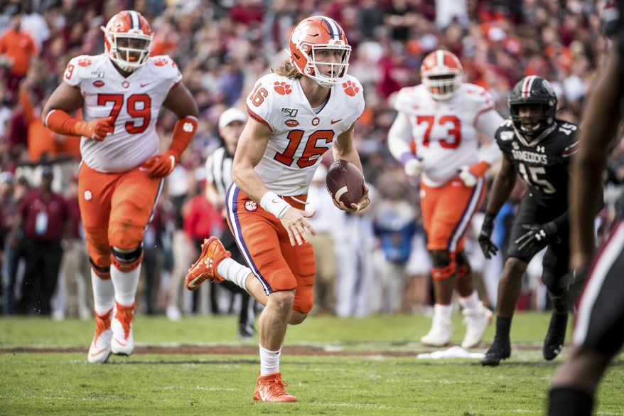 FILE - In this Nov. 30, 2019, file photo, Clemson quarterback Trevor Lawrence (16) carries the ball against South Carolina during the first half of an NCAA college football game, in Columbia, S.C. Heading into this year’s slate of conference title games a case could be made that No. 1 LSU (No. 2 CFP), No. 2 Ohio State (No. 1 CFP) and No. 3 Clemson (No. 3 CFP) have all done enough already to lose their conference championship games and still get in the College Football Playoff.(AP Photo/Sean Rayford)