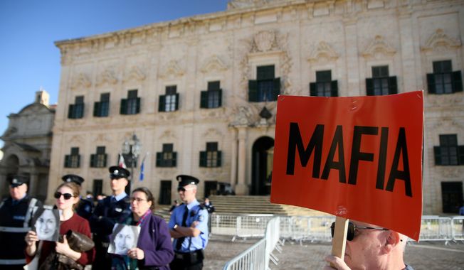 People protest outside the office of the Prime Minister at Castille, in Valletta, Malta, Tuesday, Dec. 3, 2019, as a delegation od European Union lawmakers is visiting the country after an investigation into the murder of leading investigative journalist Daphne Caruana Galizia implicated Prime Minister Joseph Muscat’s chief of staff.  (AP Photo/Rene Rossignaud)