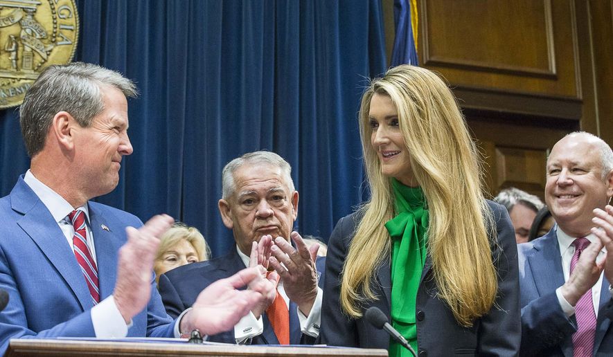 Businesswoman Kelly Loeffler, right, smiles while being introduced by Georgia Gov. Brian Kem, left,  as his pick to fill Georgia&#39;s vacant U.S. Senate seat at the Georgia State Capitol on Wednesday, Nov. 4, 2019, in Atlanta. (Alyssa Pointer/Atlanta Journal-Constitution via AP)