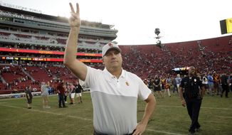 Southern California head coach Clay Helton signals to fans from midfield after a 52-35 win over UCLA in an NCAA college football game, Saturday, Nov. 23, 2019, in Los Angeles. (AP Photo/Marcio Jose Sanchez)