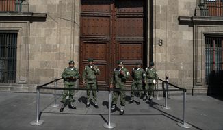Military police stand guard outside an entrance to the National Palace during a private meeting between U.S. Attorney General William Barr and Mexico&#39;s President Andres Manuel Lopez Obrador, in Mexico City, Thursday, Dec. 5, 2019. (AP Photo/Rebecca Blackwell)