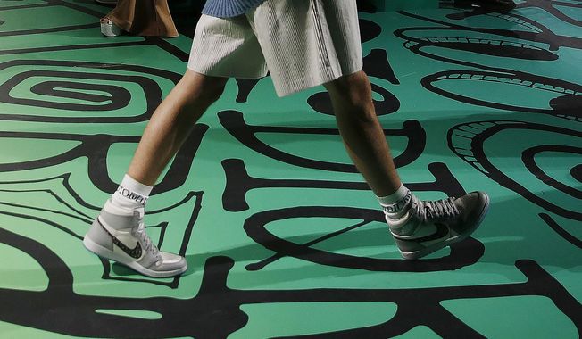 In this Tuesday, Dec. 3, 2019, photo, a model walks the runway wearing the Christian Dior pre-fall 2020 men&#x27;s fashion collection shoe Air Dior during Miami Art Week on, in Miami. (AP Photo/Brynn Anderson)