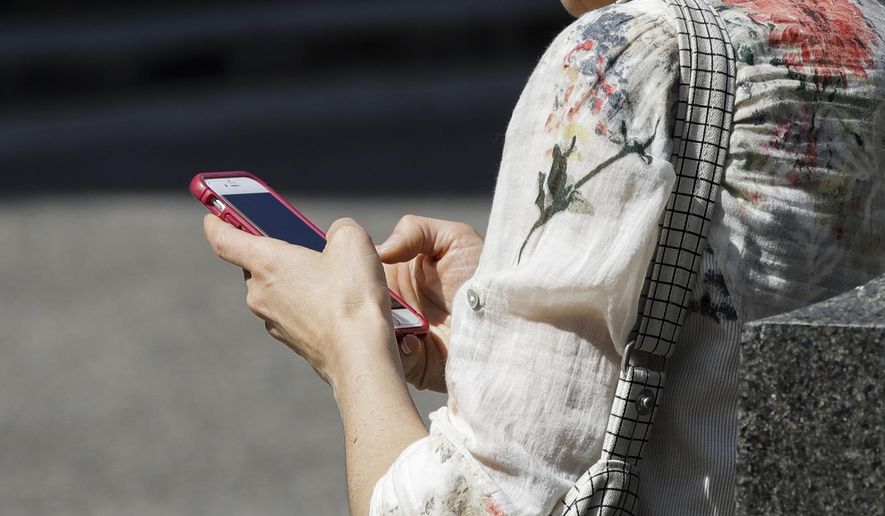 In this April 8, 2019, file photo, a woman browses her smartphone in Philadelphia. Accidental cuts and bruises to the face, head and neck from cellphones are sending increasing numbers of Americans to the emergency room, according to a study that estimates 76,000 cases over nine years. (AP Photo/Matt Rourke, File)