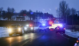 Emergency vehicles line the road near the scene of a helicopter crash Thursday, Dec. 5, 2019, near Marty, Minn. A Black Hawk helicopter with three crew members aboard crashed Thursday in central Minnesota, a state National Guard official said. (Dave Schwarz/St. Cloud Times via AP)