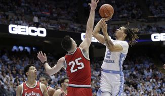 Ohio State guard D.J. Carton (3) and forward Kyle Young (25) defend while North Carolina guard Cole Anthony (2) shoots during the first half of an NCAA college basketball game in Chapel Hill, N.C., Wednesday, Dec. 4, 2019. (AP Photo/Gerry Broome)