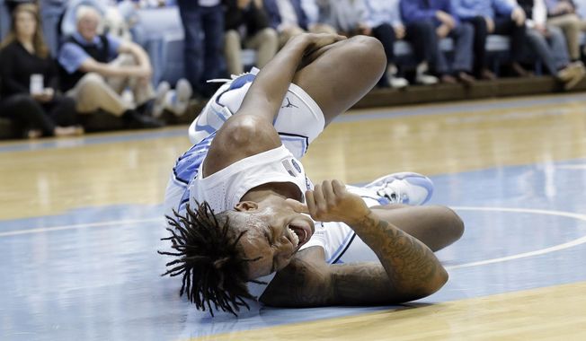 North Carolina forward Armando Bacot (5) grimaces in pain following an injury during the first half of an NCAA college basketball game against Ohio State in Chapel Hill, N.C., Wednesday, Dec. 4, 2019. (AP Photo/Gerry Broome)