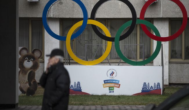 Olympic Rings and a model of Misha the Bear Cub, the mascot of the Moscow 1980 Olympic Games, left, are seen in the yard of Russian Olympic Committee building in Moscow, Russia, Thursday, Nov. 28, 2019. The WADA committee has proposed a package of sanctions including a four-year ban on hosting major events in Russia and a similar four-year sanction on Russians competing in top events like the Olympics, though they could enter as neutrals. (AP Photo/Pavel Golovkin)