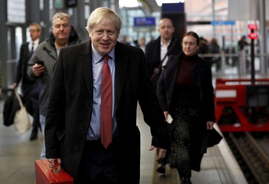 Britain's Prime Minister Boris Johnson arrives on the platform to board a train in London, Friday Dec. 6, 2019, on the campaign trail ahead of the general election on Dec. 12. Johnson pushed for the December vote, which is taking place more than two years early, in hopes of winning a majority and breaking Britain's political impasse over Brexit. (Peter Nicholls/Pool via AP)