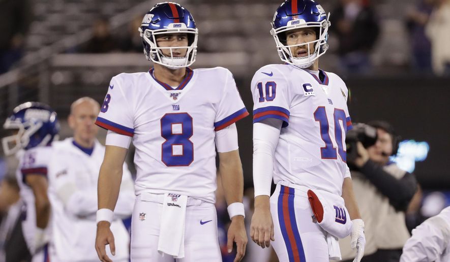 FILE - In this Nov. 4, 2019, file photo, New York Giants quarterback Daniel Jones (8) and quarterback Eli Manning (10) warm up before an NFL football game against the Dallas Cowboys, in East Rutherford, N.J. Giants quarterback Daniel Jones was kept out of practice Wednesday, Dec. 4, 2019, with a high right ankle sprain, and coach Pat Shurmur says Eli Manning “very likely” will start Monday night against the Philadelphia Eagles.Shurmur adds that Manning could very well be the starter for the rest of the season. (AP Photo/Adam Hunger, File)