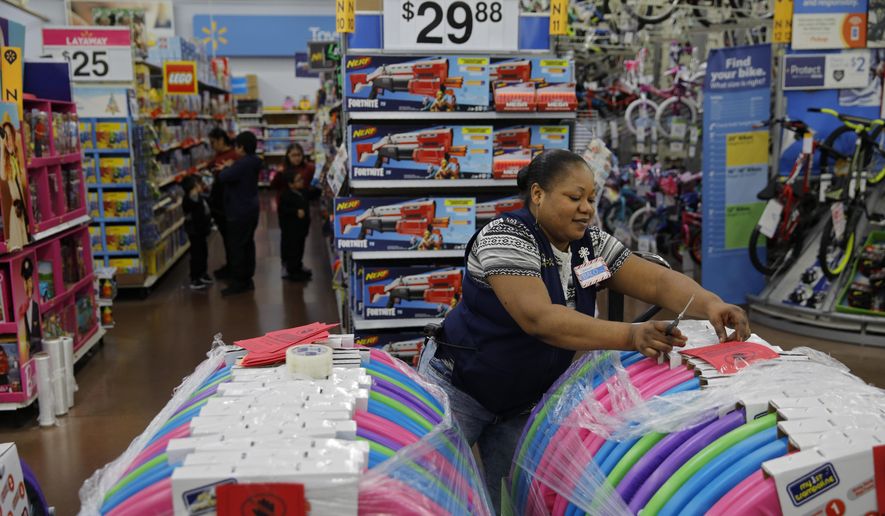 In this Nov. 27, 2019, file photo, Balo Balogun labels items in preparation for a holiday sale at a Walmart Supercenter in Las Vegas. (AP Photo/John Locher, File)