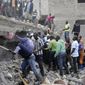 People at the scene of a collapsed building in in Tasia Embakasi, an east neighbourhood of Nairobi, Kenya on Friday Dec. 6, 2019.  A six-story building collapsed in Kenya&#39;s capital on Friday, officials said, with people feared to be trapped in the debris. Police say people have been rescued by residents using their bare hands. (AP Photo/Khalil Senosi)