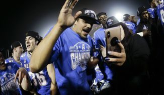 Memphis quarterback Brady White, center, celebrates after  his team defeated Cincinnati in an NCAA college football game for the American Athletic Conference championship Saturday, Dec. 7, 2019, in Memphis, Tenn. (AP Photo/Mark Humphrey)