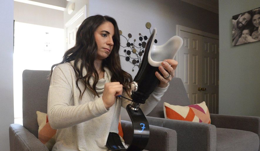 In his Monday, Nov. 25, 2019 photo, Jenn Andrews, who lost her right foot to a rare form of sarcoma, prepares to attache her running blade before heading out for a brief run in Waxhaw, N.C. Andrews, a health and wellness coach, formed a foundation &amp;quot;Move For Jenn&amp;quot; to help provide prosthetic limbs for others so that they can be more physically active. Making a positive impact on others has helped her heal emotionally. Andrews attaches her running blade before heading out for a brief run. (John D. Simmons/The Charlotte Observer via AP)