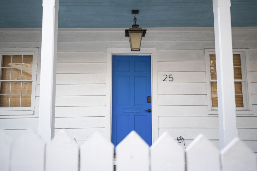 This Nov. 19, 2019 photo, shows a house on Sires Street featuring a blue door with a haint blue porch ceiling in Charleston, S.C. (Lauren Petracca/The Post And Courier via AP)