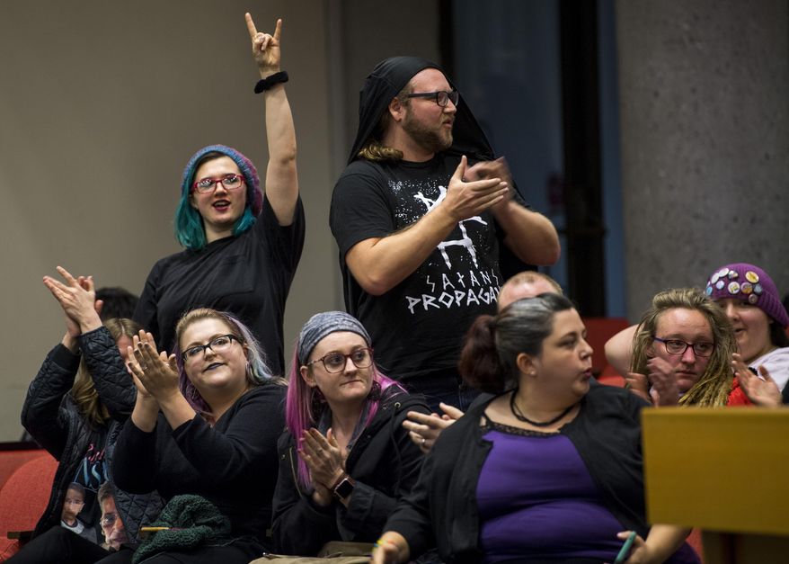 In this Dec. 4, 2019, photo opponents of the Bible Release Program show their support of one speaker's message during the public forum portion of the Knox County School Board Meeting held at the City-Council building in Knoxville, Tenn. (Brianna Paciorka/Knoxville News Sentinel via AP)